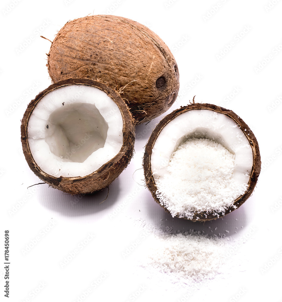 One whole and two cracked coconut halves with shavings isolated on white background One whole and two cracked coconut halves with shavings isolated on white background