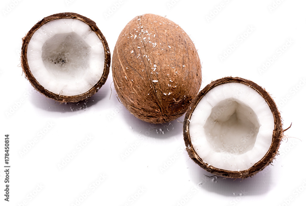 One whole coconut and two cracked coconut halves with shavings isolated on white background One whole coconut and two cracked coconut halves with shavings isolated on white background
