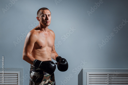 handsome man or healthy boxer or Thai boxer with six pack wearing boxing gloves photo