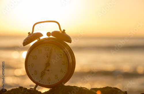 An alarm clock by the sea at dawn