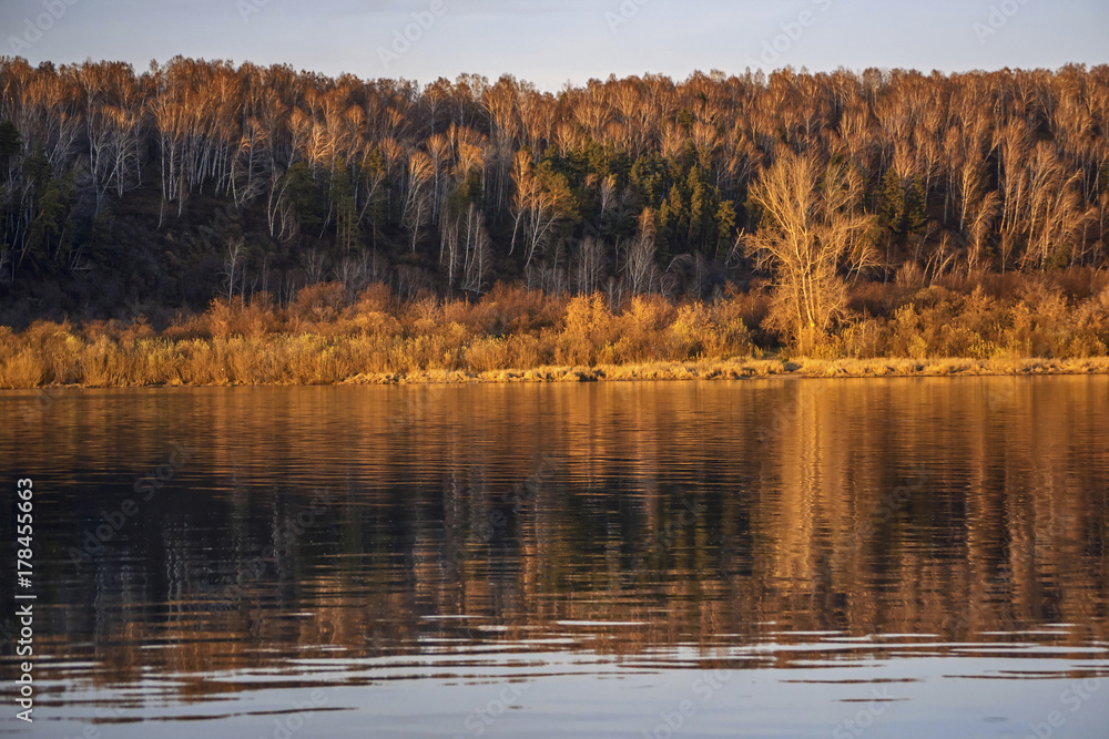 Autumn sunset with river and forest reflection