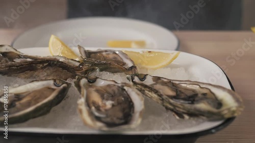 fresh oyster on hand chef, seafood restaurant, glove with lemon on ice photo