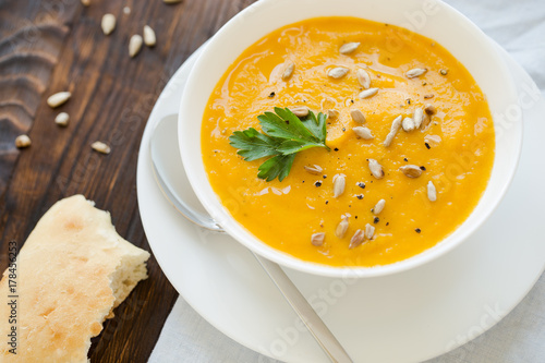 Dinner with carrot soup-puree served in white bowl