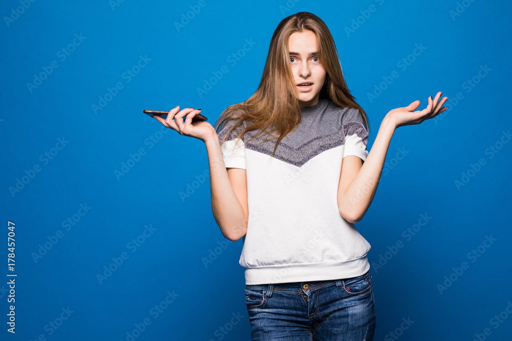 woman phone in hands asking gesture on blue background woman phone in hands asking gesture on blue background