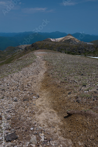 Rocky hiking trail over the mountain ranges of Daisetsuzan National Park, Hokkaido, Japan photo