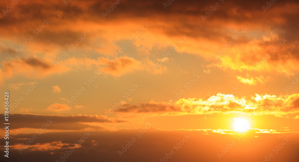 Beautiful sunset on sky. Gold sun lightens the clouds. The sun is on the right side.