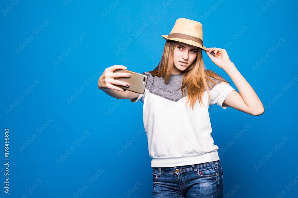 Portrait of beautiful young woman smiling against blue background Portrait of beautiful young woman smiling against blue background