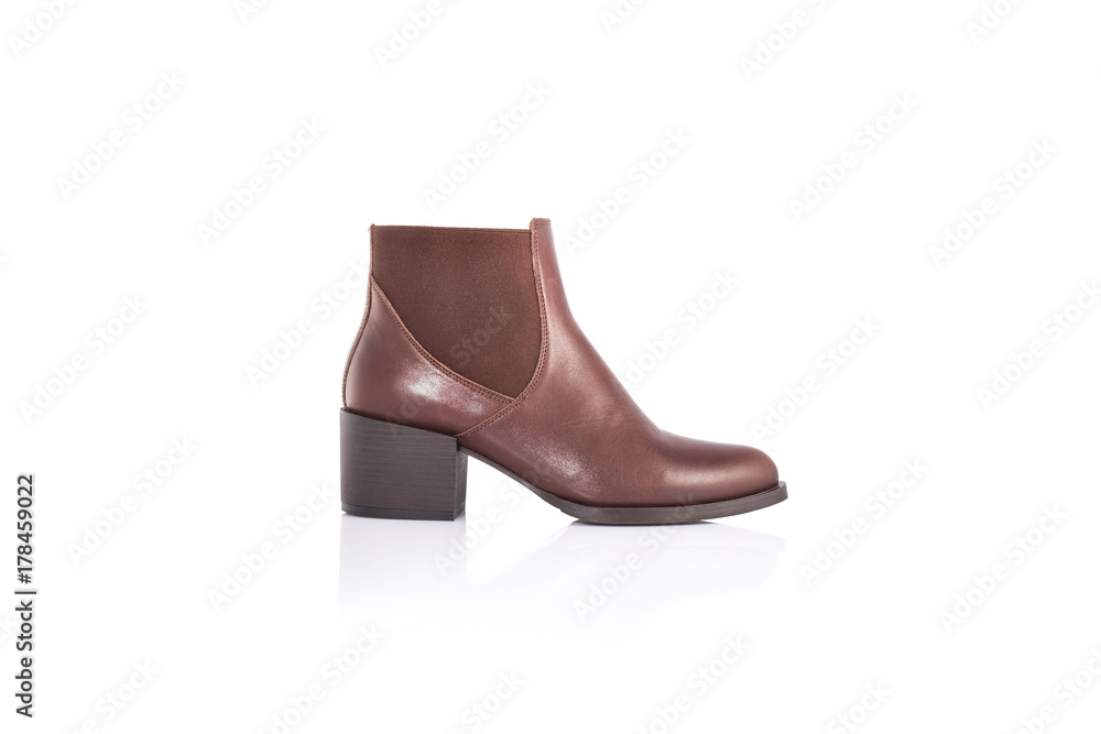 Close up of a women's brown leather chelsea boots on white background with reflection. Fashion advertising shoes photos. Close up of a women's brown leather chelsea boots on white background with reflection. Fashion advertising shoes photos.