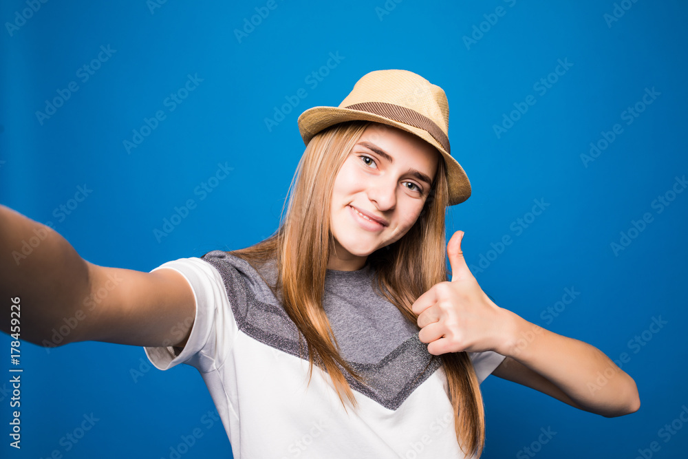 Portrait of beautiful young woman smiling against blue background Portrait of beautiful young woman smiling against blue background