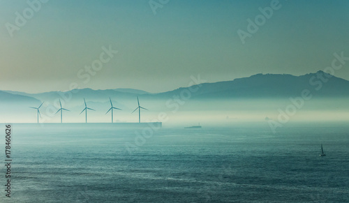 Windmill under the sea mist at dusk photo