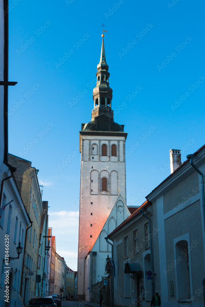 Old town of Tallinn. Red tiled roofs, the church of St. Olaf, the Baltic Sea in the background. Card. Estonia.