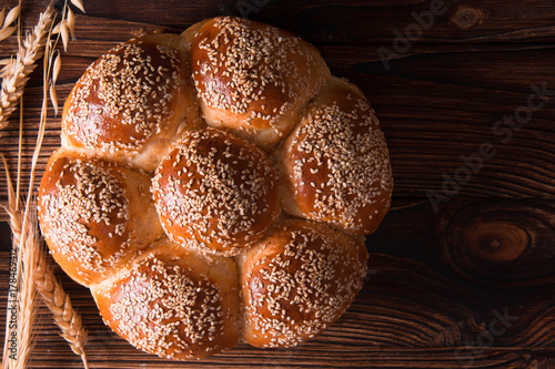 Bread with sesame seeds on a wooden background.