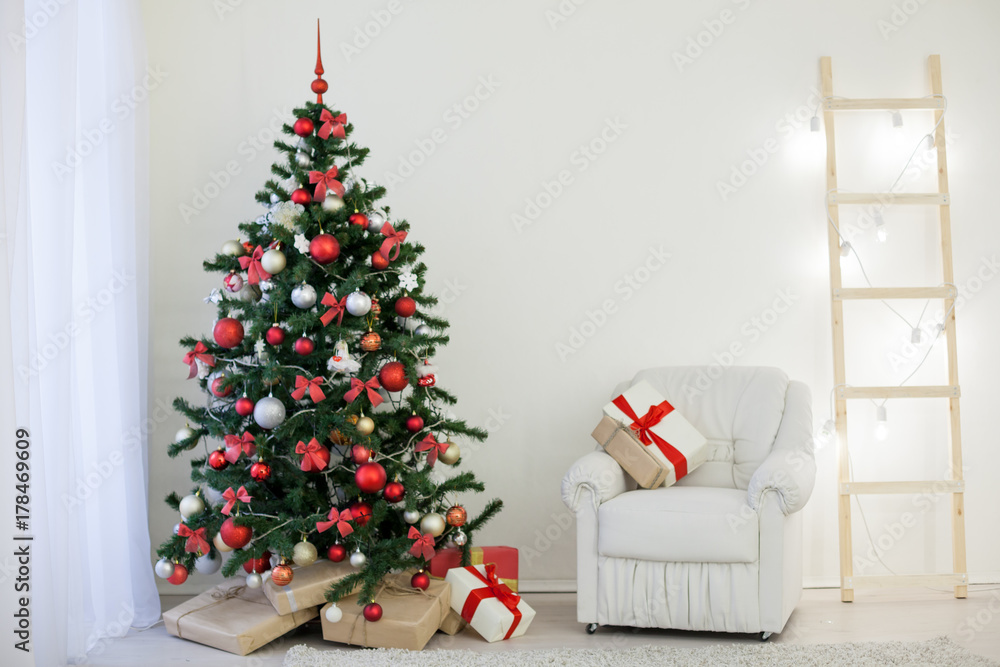 Christmas tree in a white room with a Christmas greeting gifts Christmas tree in a white room with a Christmas greeting gifts