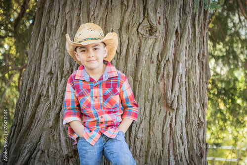 Mixed Race Young Boy Wearing Cowboy Hat Standing Outdoors. © Andy Dean