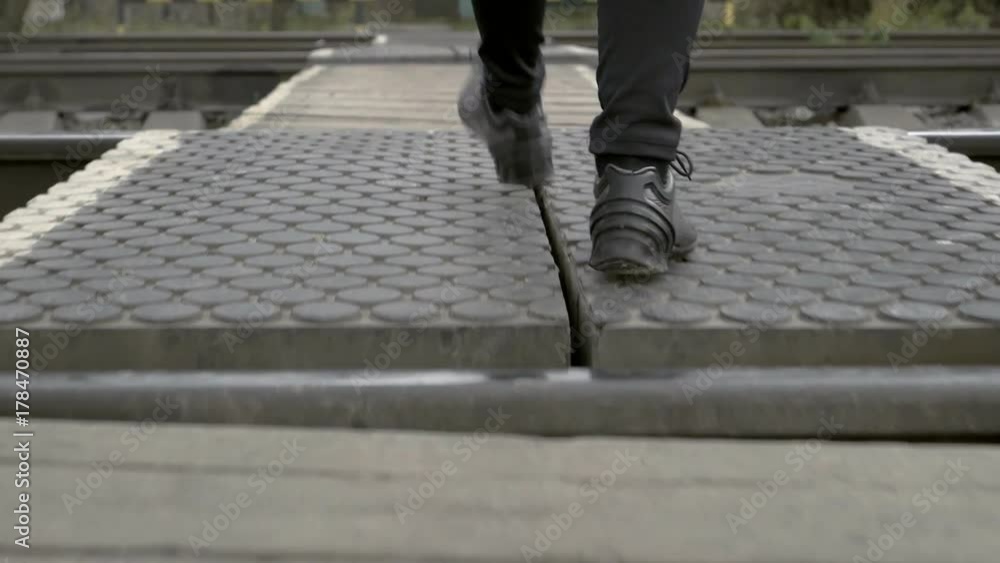 Man walking on a wooden railroad crossings. Man walking on a wooden railroad crossings.