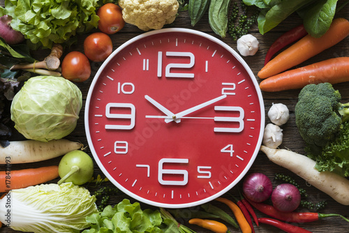 Food clock. Healthy food concept on wooden table photo