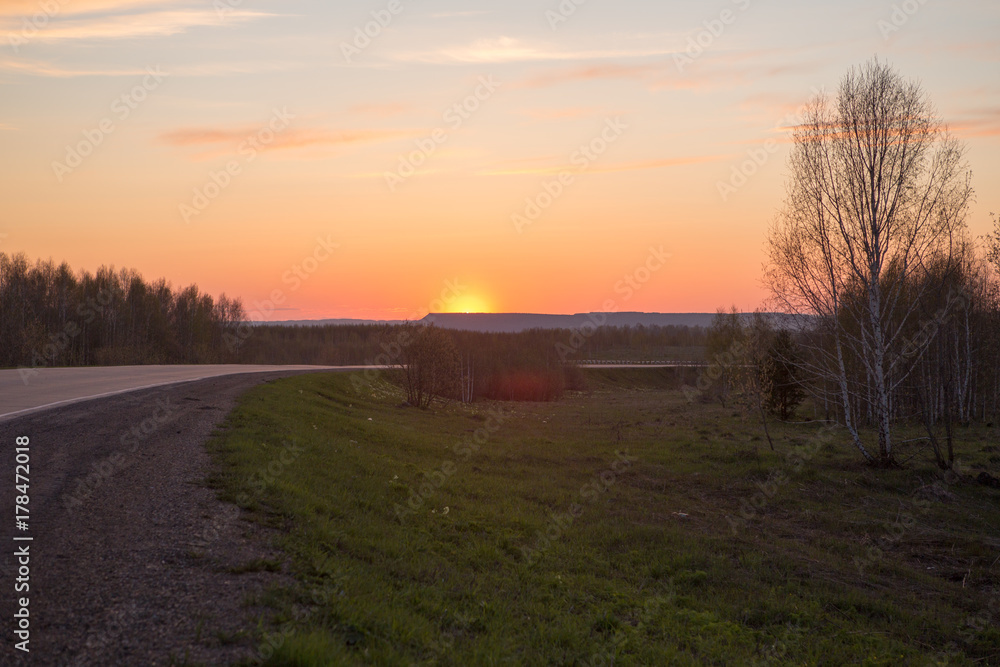 The curve of the road in the mountains. Sunset