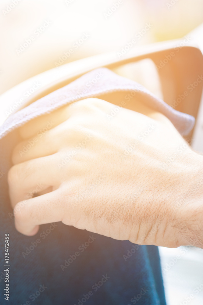The vertical view of adult human hand with blue microfibre cloth is cleaning the mirror. Clean car concept.Vertical side view The vertical view of adult human hand with blue microfibre cloth is cleaning the mirror. Clean car concept.Vertical side view