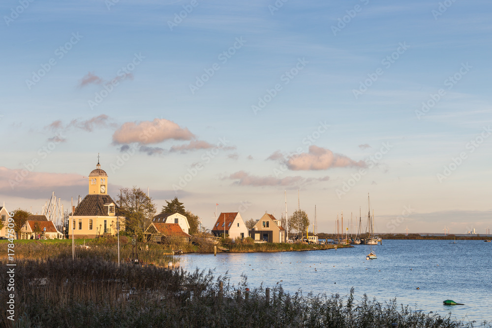 Fototapeta premium Protestant church in Durgerdam and houses overlooking the IJsselmeer