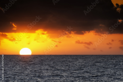 Magnifico tramonto sul mare con sole in evidenza e riflessi