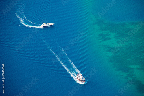 White yachts sailing with foam waves in turquoise sea. Drone view © timltv