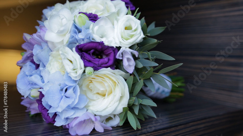 Perfect bouquet of creme luxurious roses for wedding  birthday or Valentine s day. Black old wooden background  top view. the bride s bouquet on black wood. Blue and white and pink roses