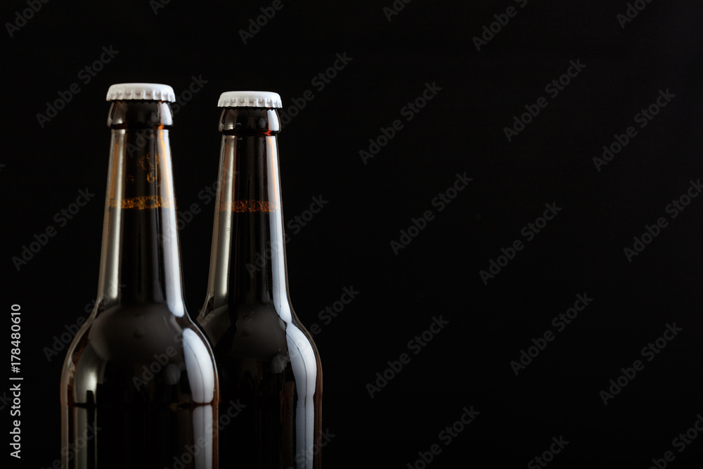 Closeup of two beer bottles isolated on black background Closeup of two beer bottles isolated on black background