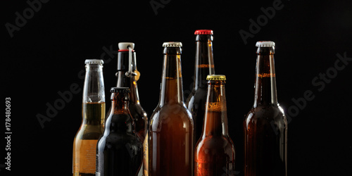 Fotografie Set of beer bottles on black background