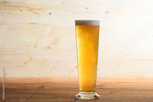 A glass of beer on a wooden table, copy space