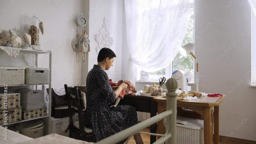 Woman sewing a doll. Camera movement. Woman sewing a doll. Camera movement.