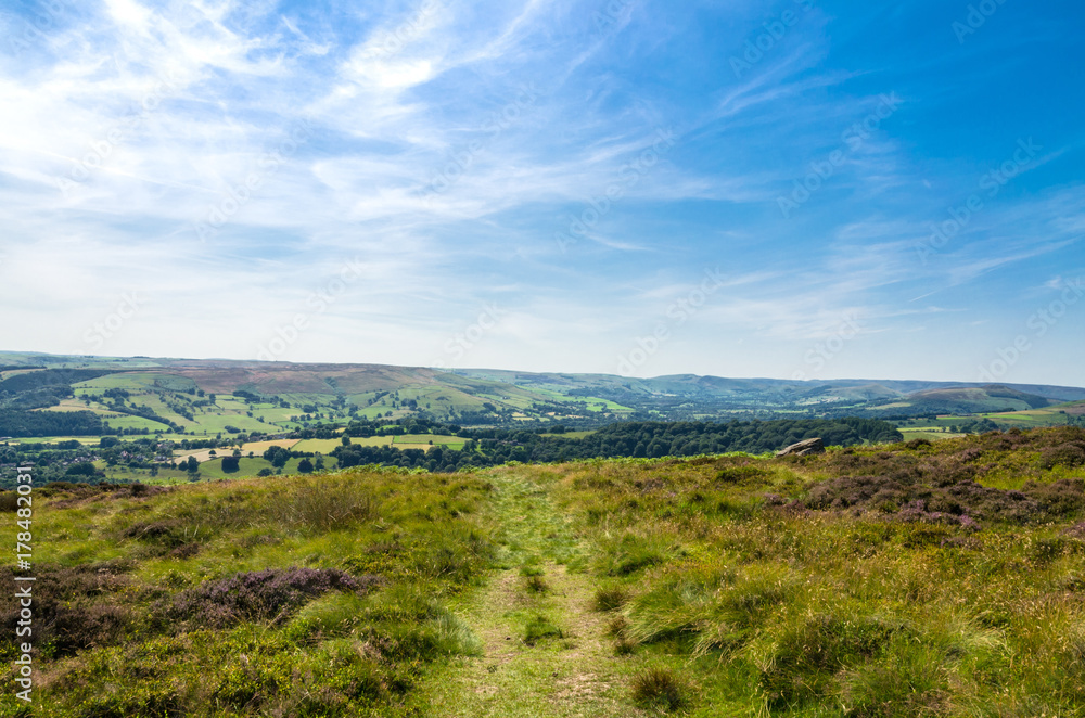 A footpath in the romantic Peak District countryside in summer, Derbyshire, England A footpath in the romantic Peak District countryside in summer, Derbyshire, England