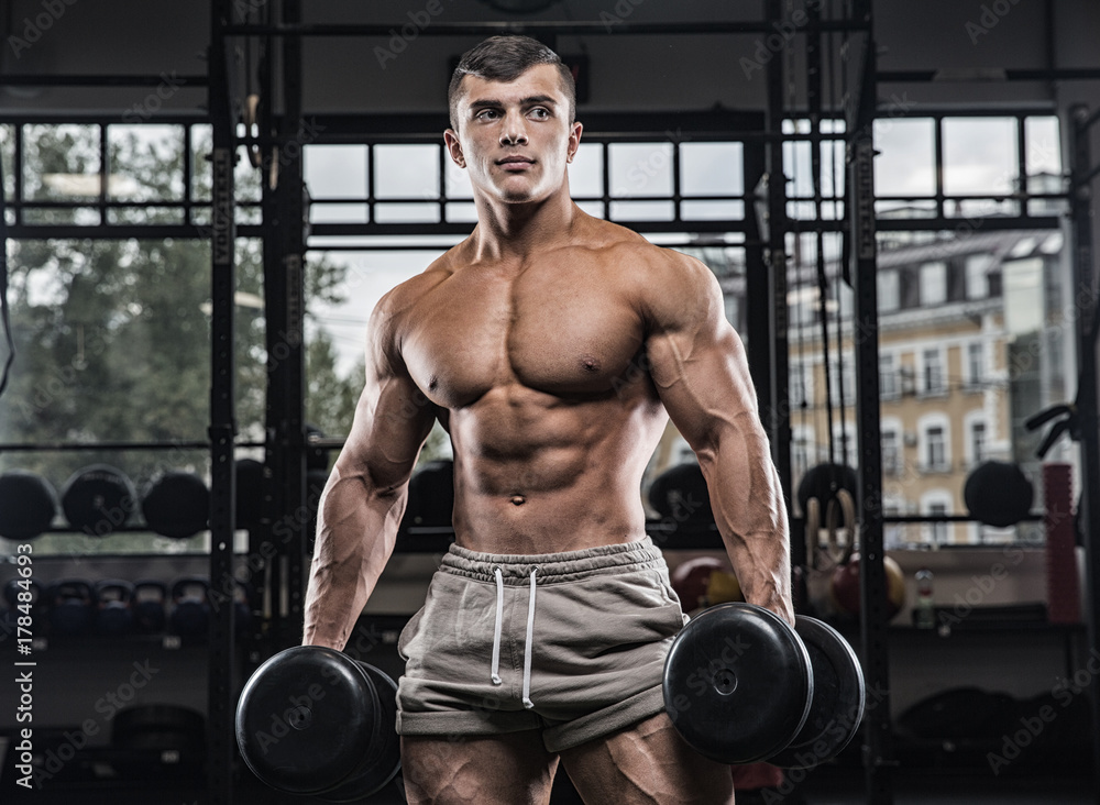 Attractive tall muscular bodybuilder doing heavy deadlifts in moder fitness center. Attractive tall muscular bodybuilder doing heavy deadlifts in moder fitness center.