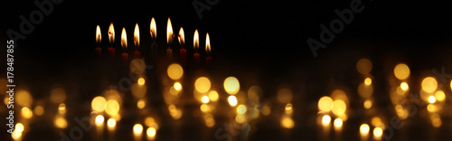 low key image of jewish holiday Hanukkah background with burning candles