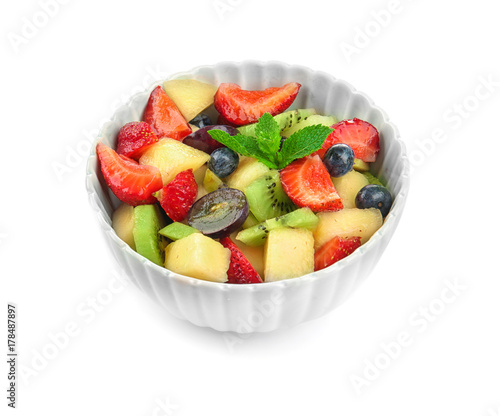 Bowl with delicious fruit salad on white background