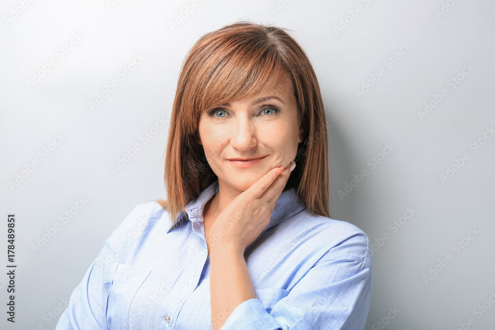 Attractive mature woman on light background Attractive mature woman on light background