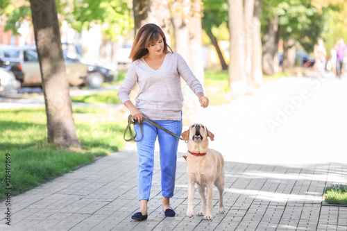 Mature woman walking her dog in park