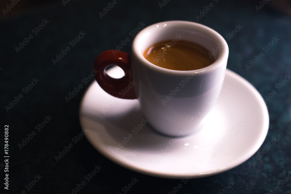 A cup of coffee is americano on a dark background. A cup of coffee is americano on a dark background.