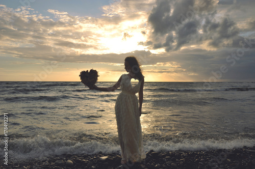 Sunset on the seaside. Girl holding heart. Empty. Surreal.
