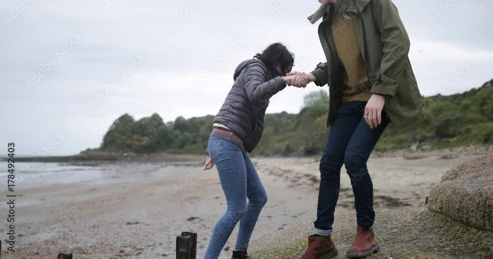 Boyfriend helping girlfriend climb a rock Boyfriend helping girlfriend climb a rock