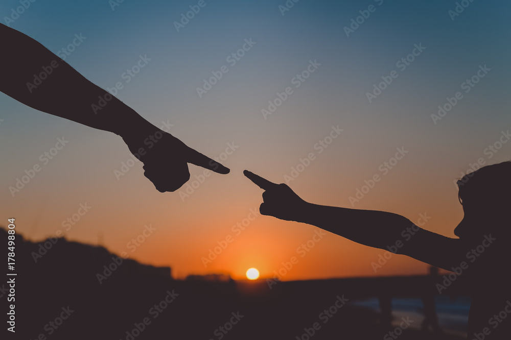 Back side view silhouettes of father holding his child hand over sunset background Back side view silhouettes of father holding his child hand over sunset background
