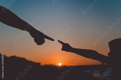 Back side view silhouettes of father holding his child hand over sunset background © aquar