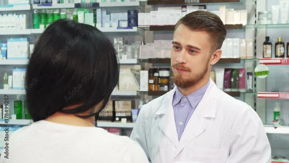 The pharmacist and his client are in the pharmacy. They have a sweet talk. Then the pharmacist gives the woman a bag with her purchases. He slaps her friendly on the shoulder The pharmacist and his client are in the pharmacy. They have a sweet talk. Then the pharmacist gives the woman a bag with her purchases. He slaps her friendly on the shoulder