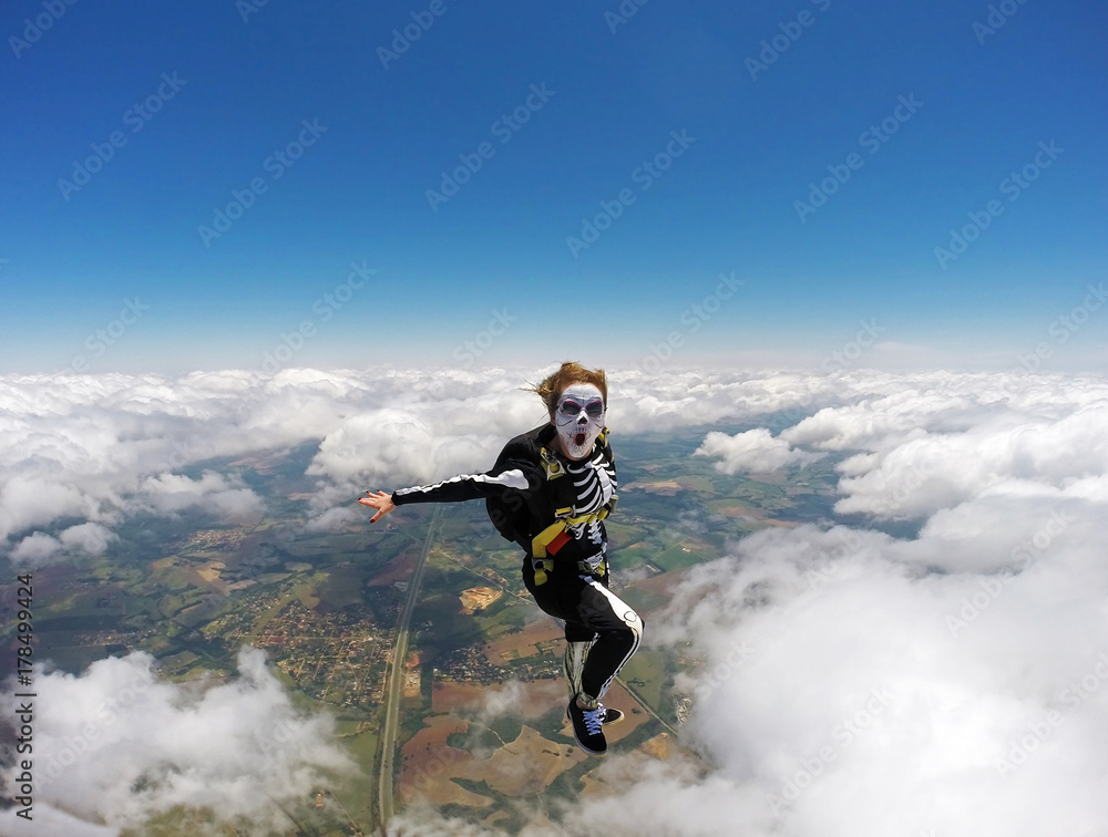 Woman costumed skeleton in free fall. Skydiving Happy Halloween.