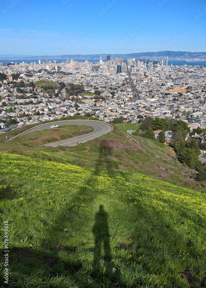 A person's shadow beneath Sutro Tower on Twin Peaks, San Francisco, CA overlooking the Financial District