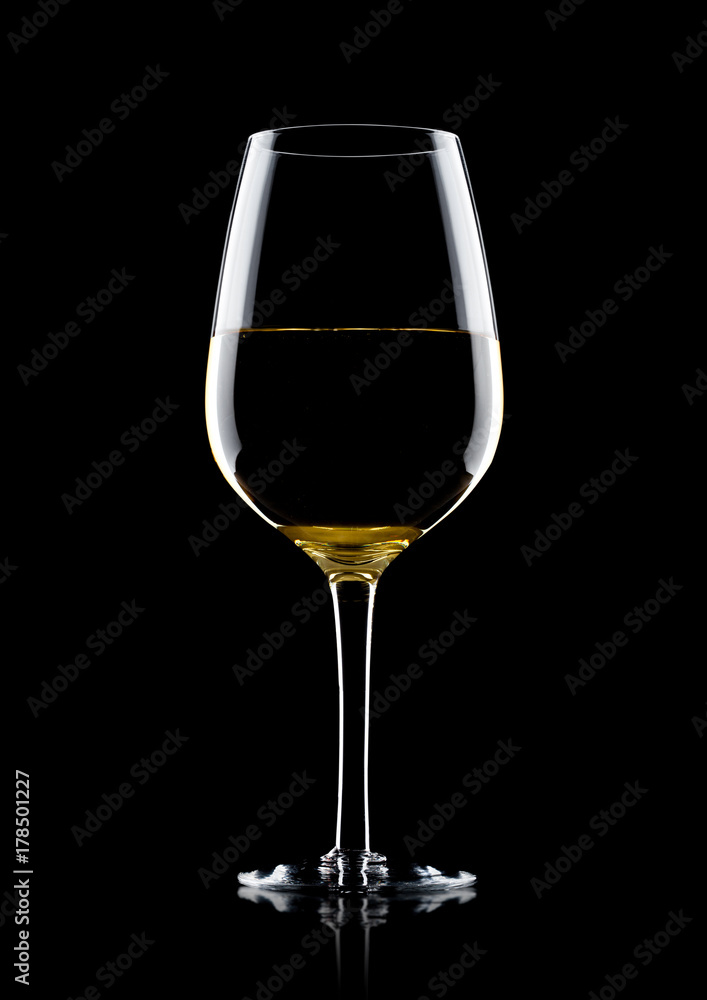 Glass of white wine with reflection on black Glass of white wine with reflection on black