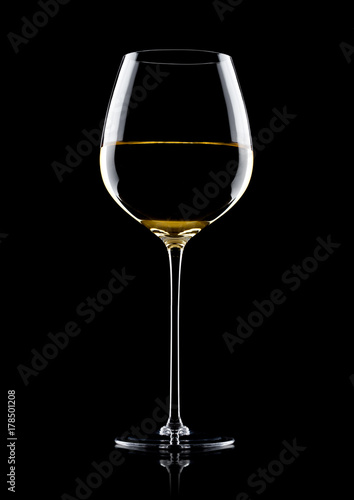 Glass of white wine with reflection on black