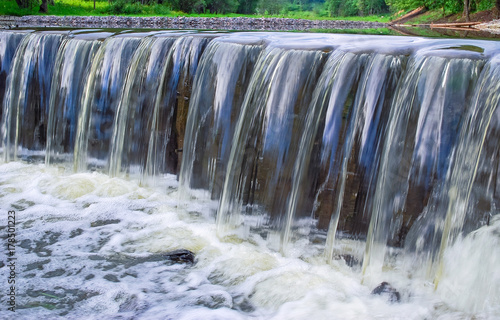 Fototapeta Naklejka Na Ścianę i Meble -  Decorative designed dam on a small river in the form of a waterfall