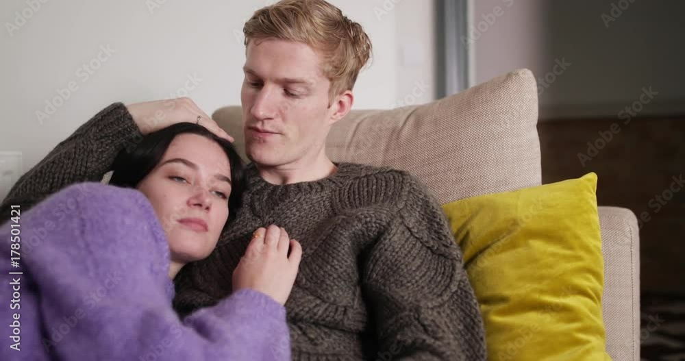 Couple at home cuddling on sofa Couple at home cuddling on sofa