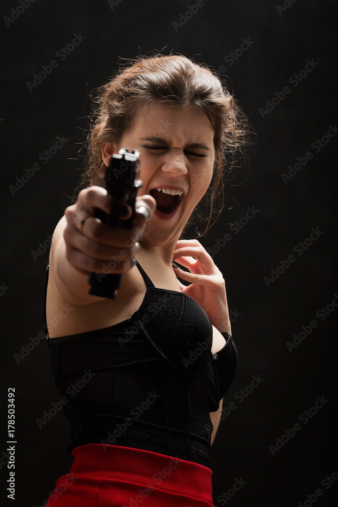 girl with gun and closed eyes on black background aiming at camera screaming girl with gun and closed eyes on black background aiming at camera screaming