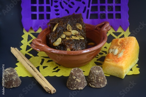 Mexican traditional pumpkin sweet made with piloncillo and cinammon on a clay pot, known as calabaza en tacha with ornamental papel picado